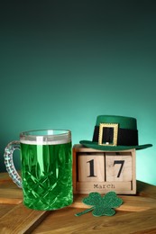 St. Patrick's day celebrating on March 17. Green beer, block calendar, leprechaun hat and decorative clover leaf on wooden table