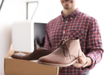 Photo of Young man choosing shoes in store