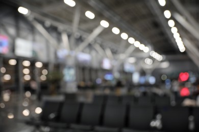 Photo of Blurred view of waiting area with seats in airport terminal