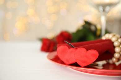 Photo of Elegant place setting on white table, closeup with space for text. Valentine's day romantic dinner