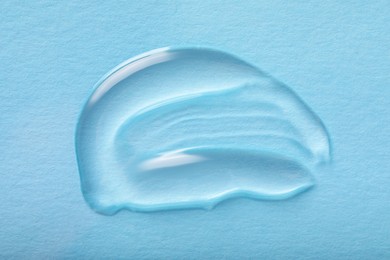 Photo of Smear of ointment on light blue background, top view