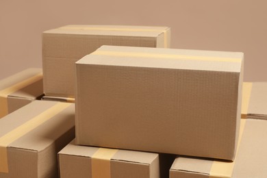 Photo of Many closed cardboard boxes on light brown background