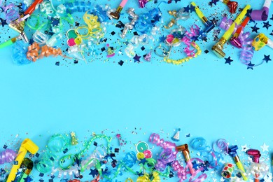 Photo of Colorful serpentine streamers, confetti and party horns on light blue background, flat lay. Space for text