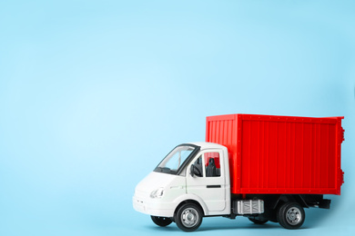 Photo of Toy truck on blue background, space for text. Logistics and wholesale concept