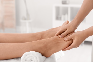 Woman receiving foot massage in wellness center, closeup