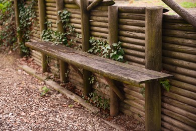 Wooden bench near fence outdoors on spring day