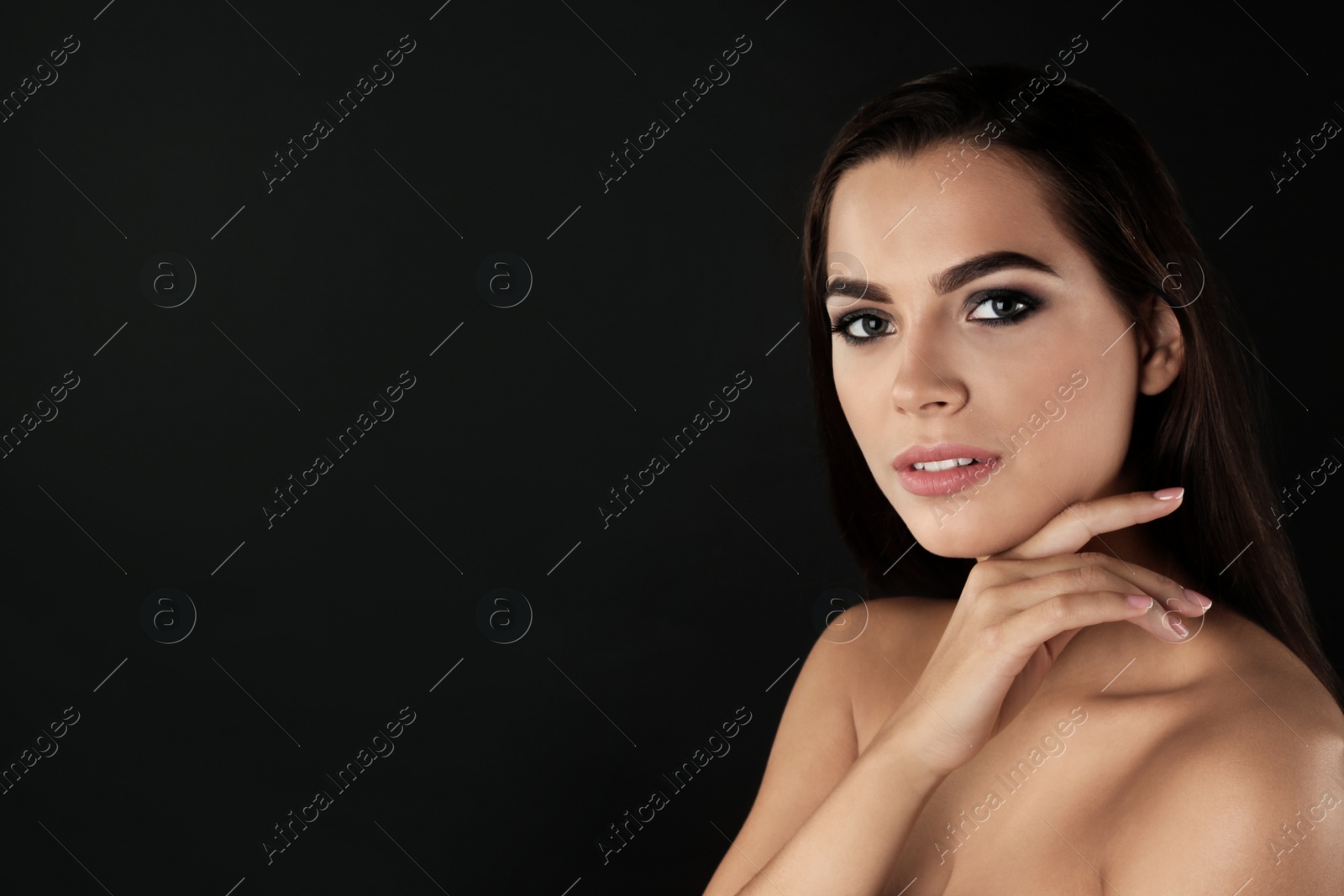 Photo of Portrait of beautiful woman with stylish makeup on dark background. Space for text