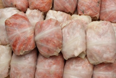 Photo of Uncooked stuffed cabbage rolls as background, top view