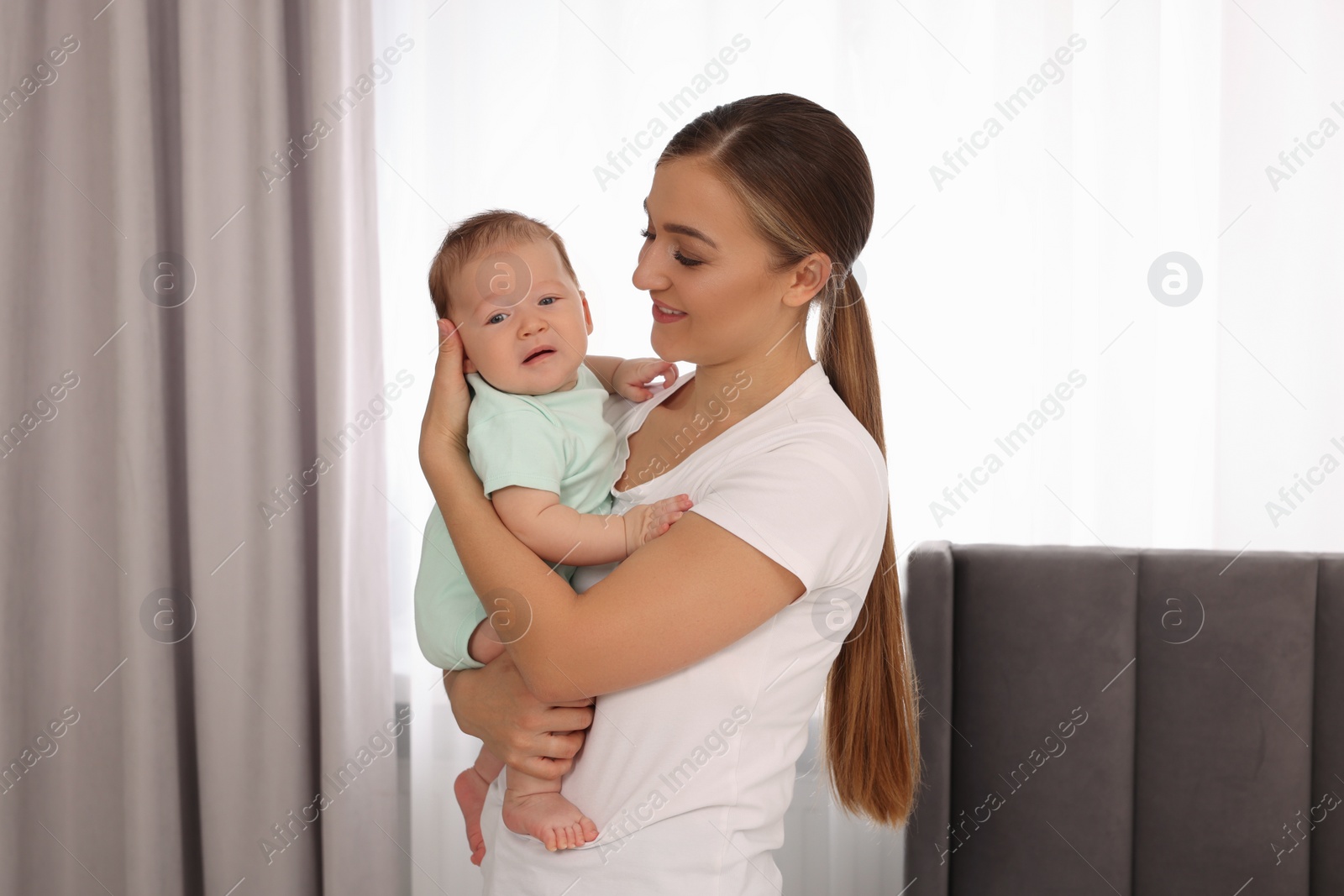 Photo of Mother holding her cute newborn baby at home