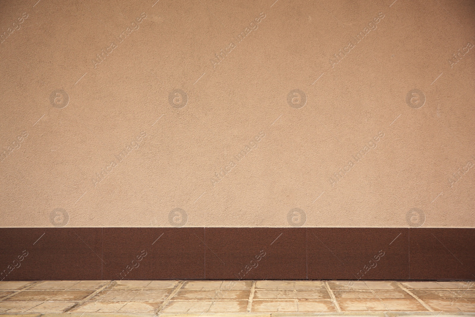 Photo of Beautiful plaster beige wall and concrete pavement