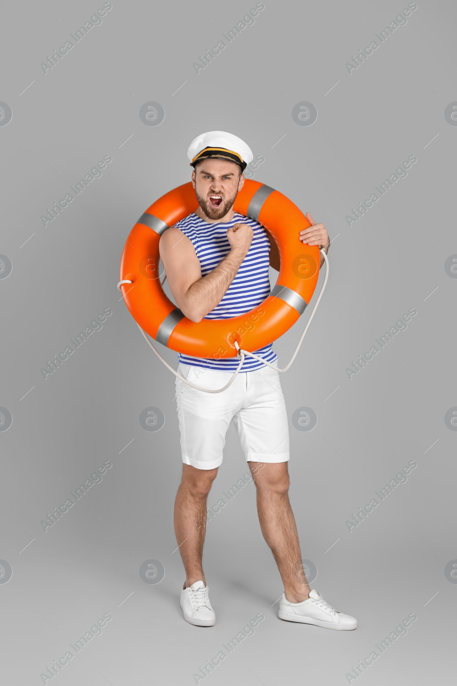 Photo of Sailor with ring buoy on light grey background