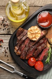 Delicious grilled beef steak with vegetables and spices on wooden table, flat lay