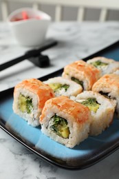 Delicious sushi rolls served on white marble table