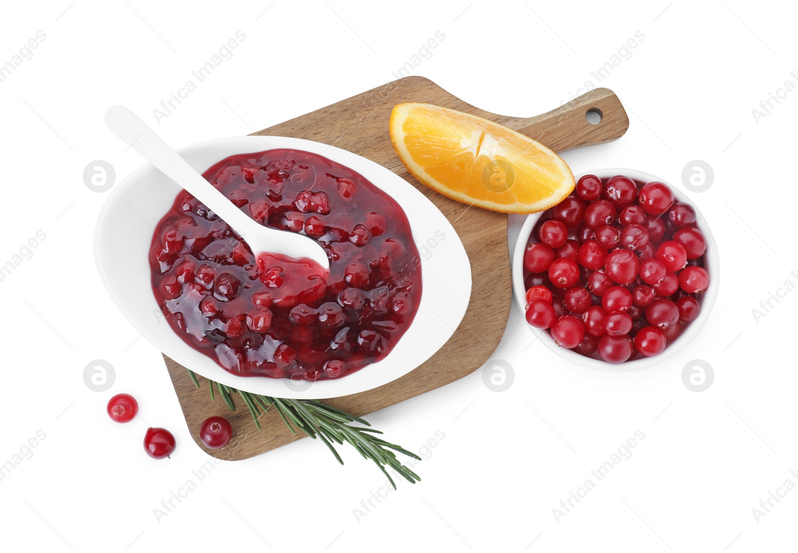 Photo of Tasty cranberry sauce in bowl, fresh berries, orange wedge and rosemary isolated on white, top view