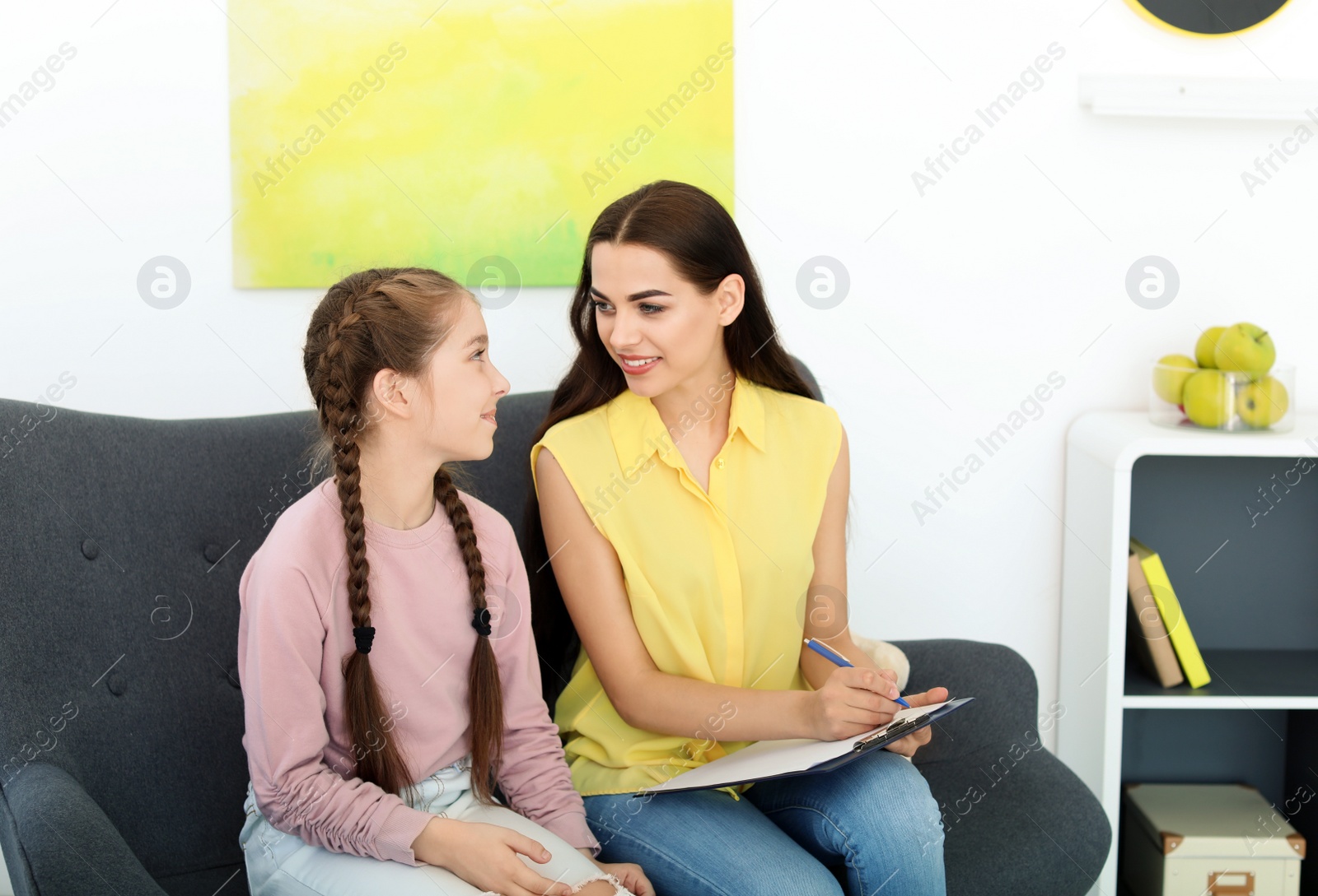 Photo of Child psychologist working with little girl in office