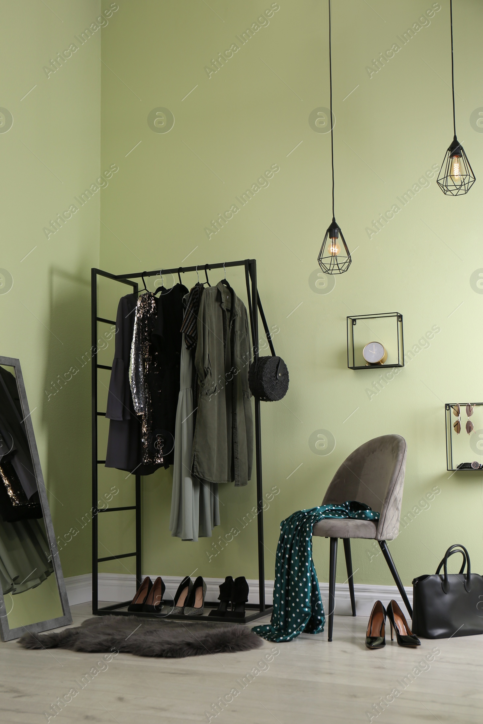 Photo of Modern dressing room interior with clothing rack, chair and mirror