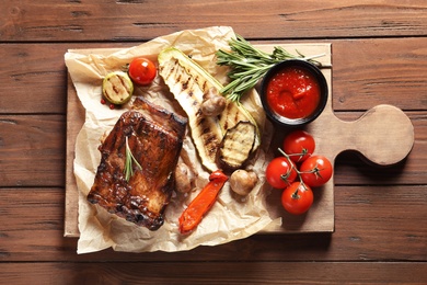 Photo of Delicious meat served for barbecue party on wooden background, flat lay