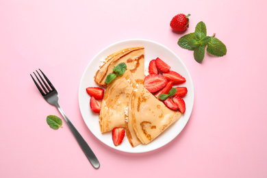 Delicious thin pancakes with strawberries and cottage cheese on pink background, flat lay