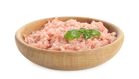 Raw chicken minced meat with basil in bowl on white background