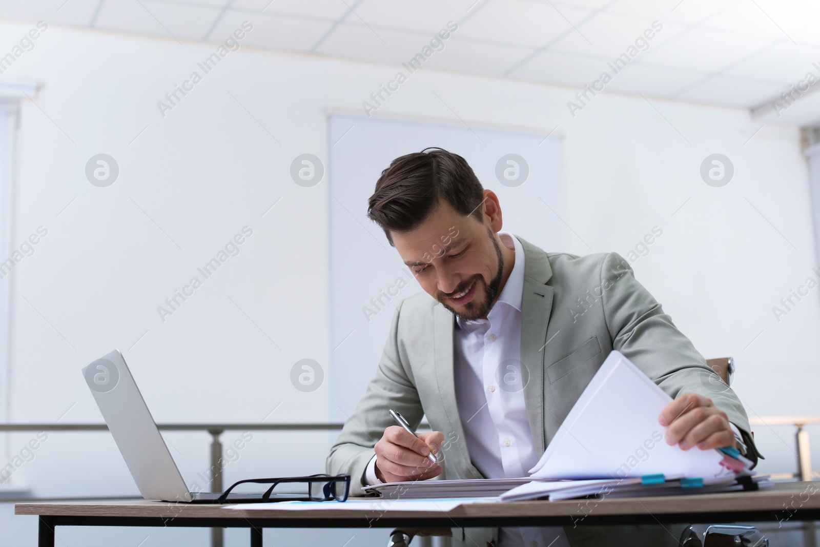 Photo of Businessman working with documents at table in office