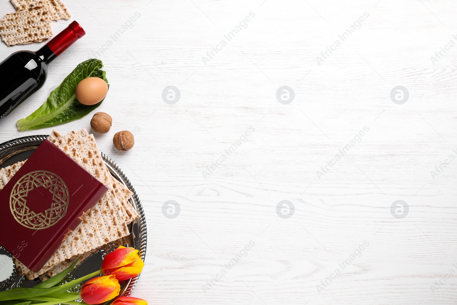 Photo of Flat lay composition with symbolic Pesach (Passover Seder) items on white wooden table, space for text