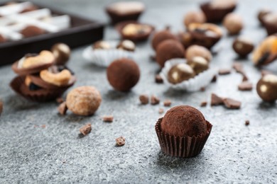 Photo of Delicious chocolate candies on grey table. Space for text