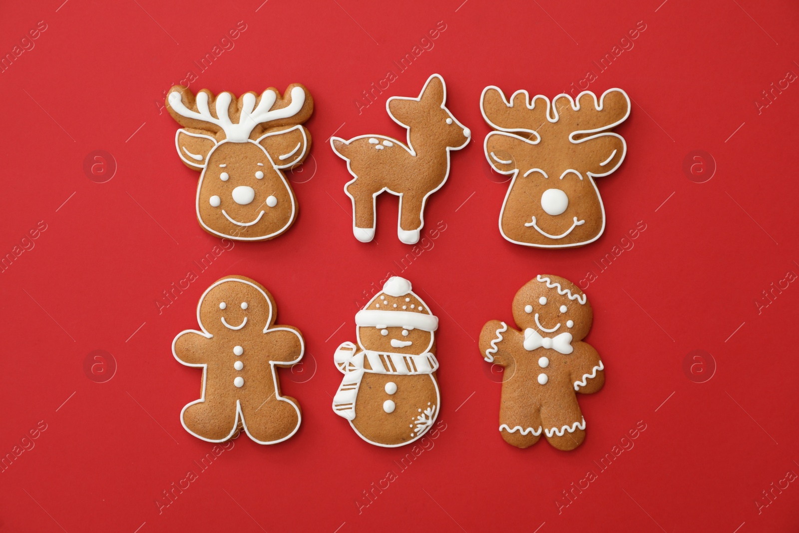 Photo of Different Christmas gingerbread cookies on red background, flat lay