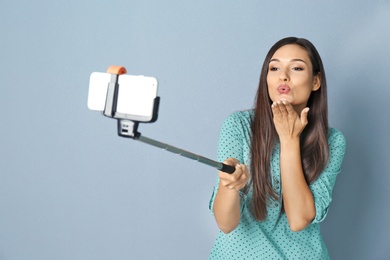 Photo of Young beautiful woman taking selfie against grey background