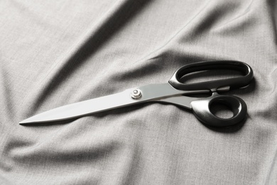 Scissors on soft grey fabric. Tailoring equipment