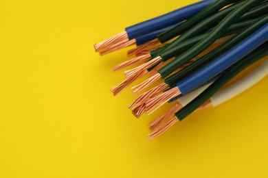 Electrical wires on yellow background, closeup. Space for text