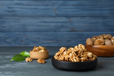 Photo of Composition with walnuts in dish on table. Space for text