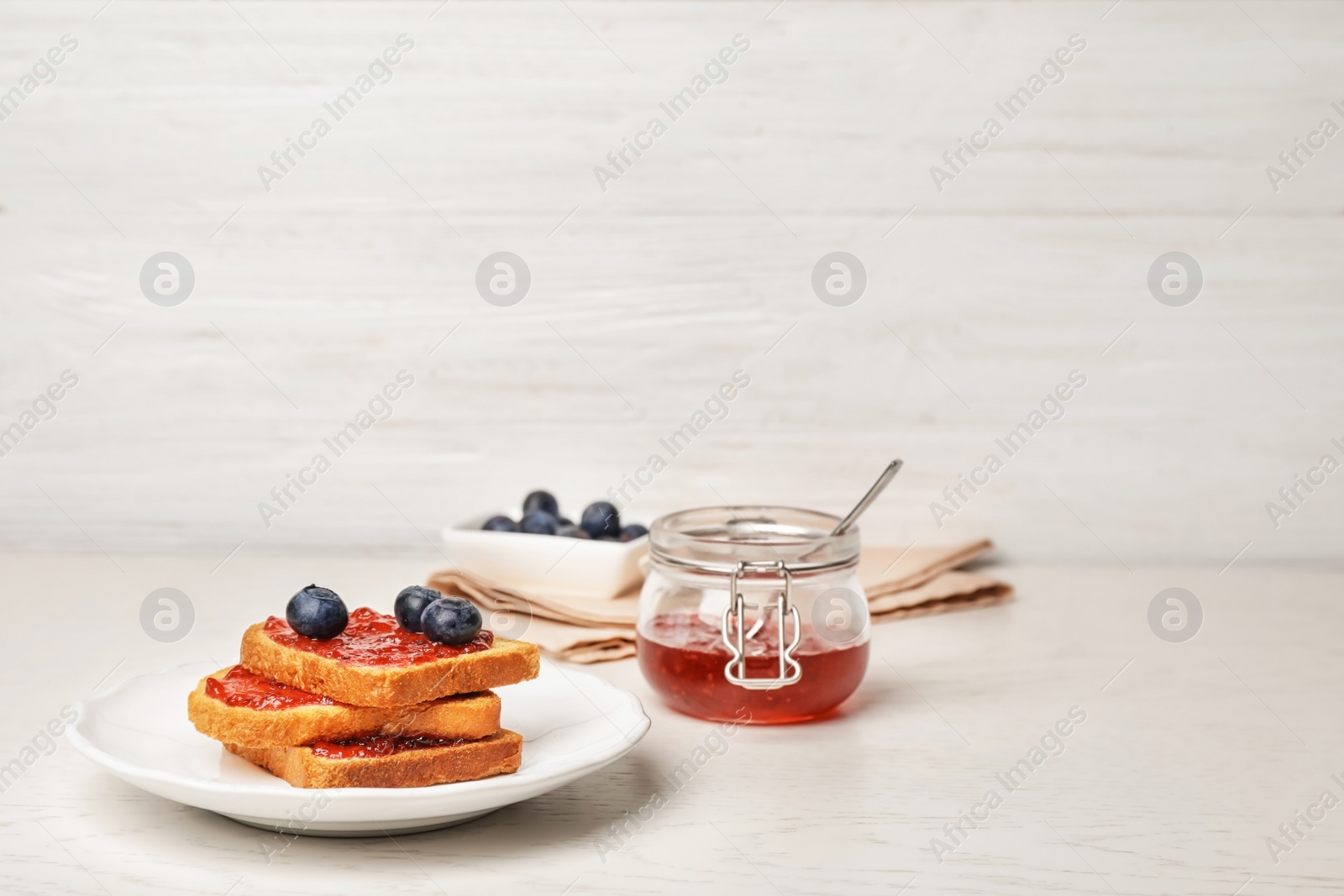 Photo of Toasts with jam and berries on wooden table