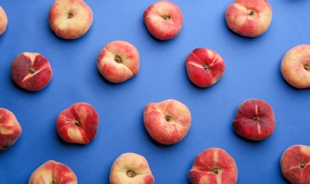 Photo of Fresh donut peaches on blue background, flat lay