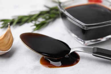 Photo of Organic balsamic vinegar and cooking ingredients on white table, closeup