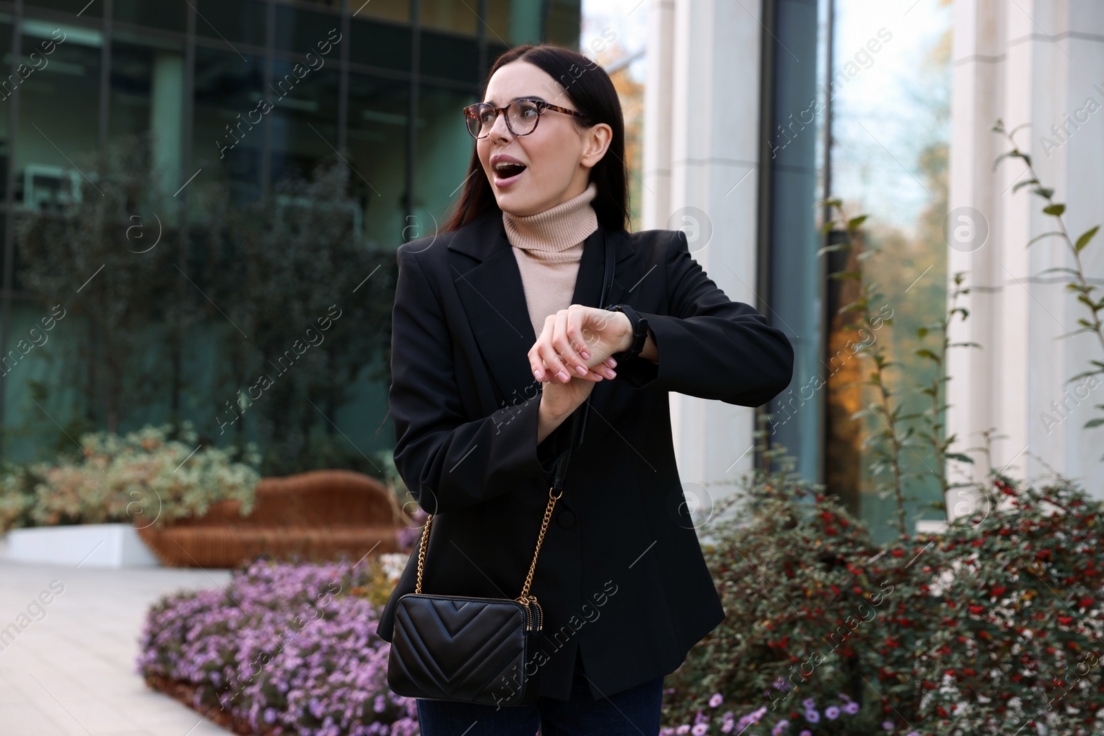 Photo of Emotional woman checking time on watch outdoors. Being late concept