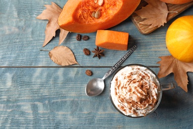 Photo of Flat lay composition with glass cup of tasty pumpkin spice latte and space for text on wooden background