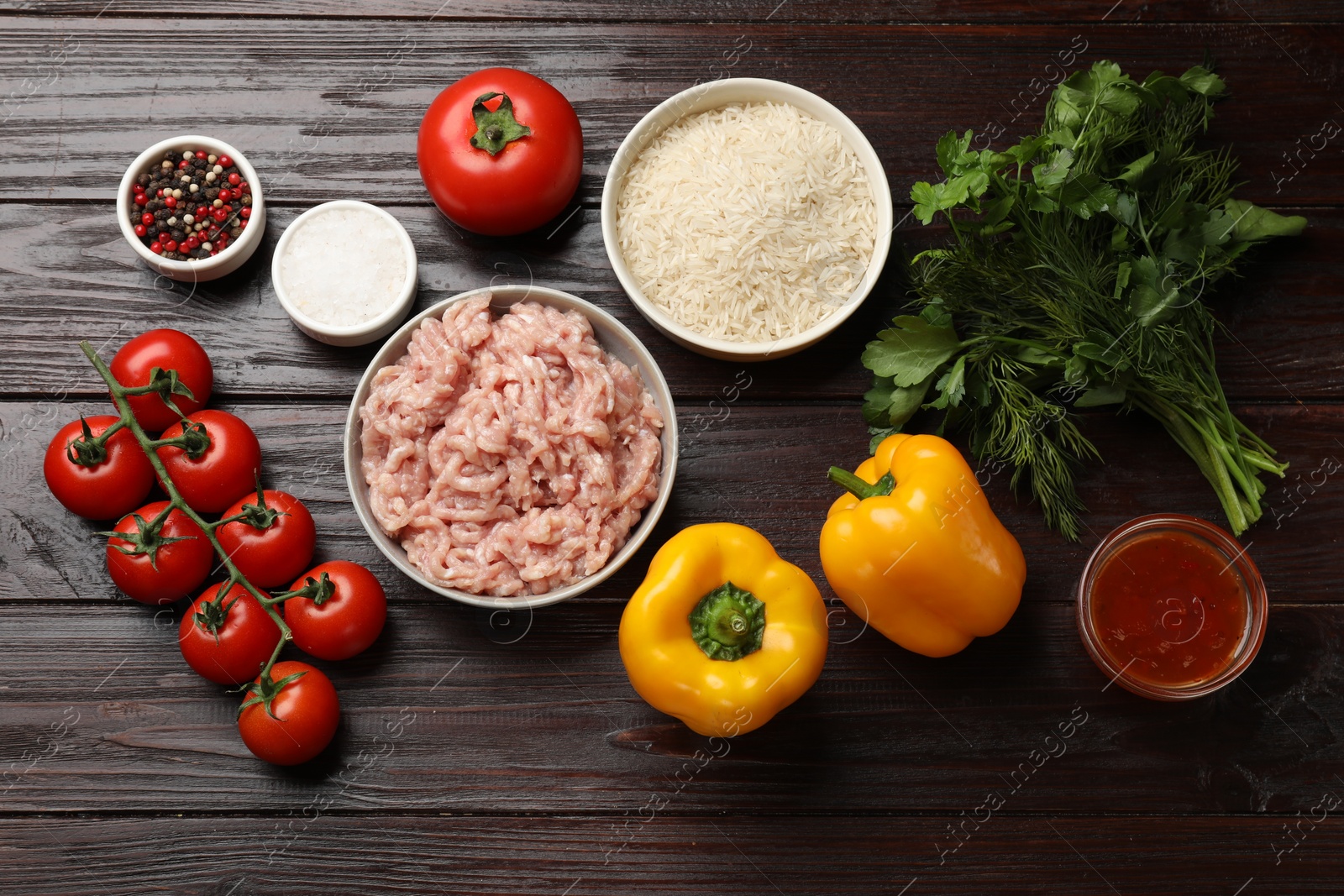 Photo of Making stuffed peppers. Ground meat and other ingredients on wooden table, flat lay