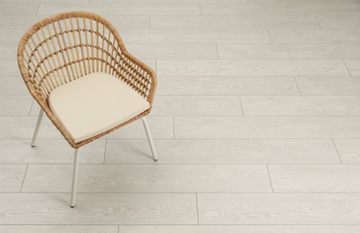 Photo of Stylish wicker armchair on floor. Space for text