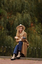 Happy woman with camera in autumn park