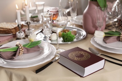 Photo of Festive Passover table setting with Torah. Pesach celebration