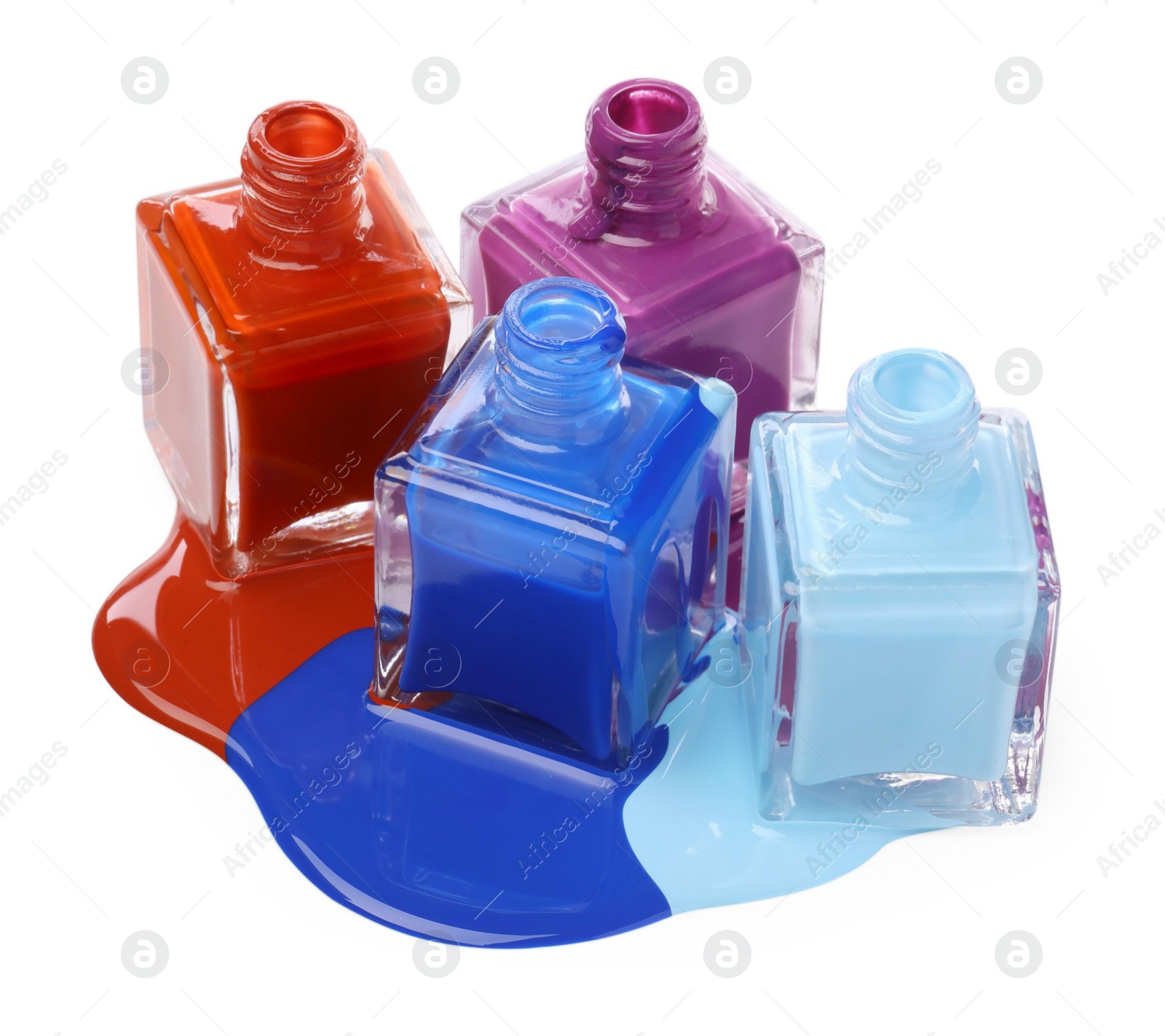 Photo of Puddle of different bright nail polishes and bottles isolated on white