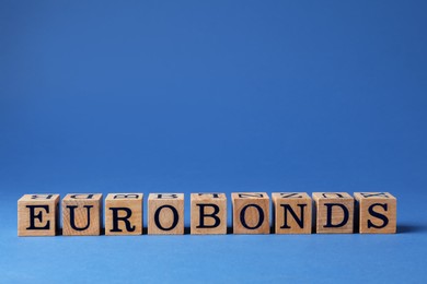 Photo of Word Eurobonds made of wooden cubes with letters on blue background