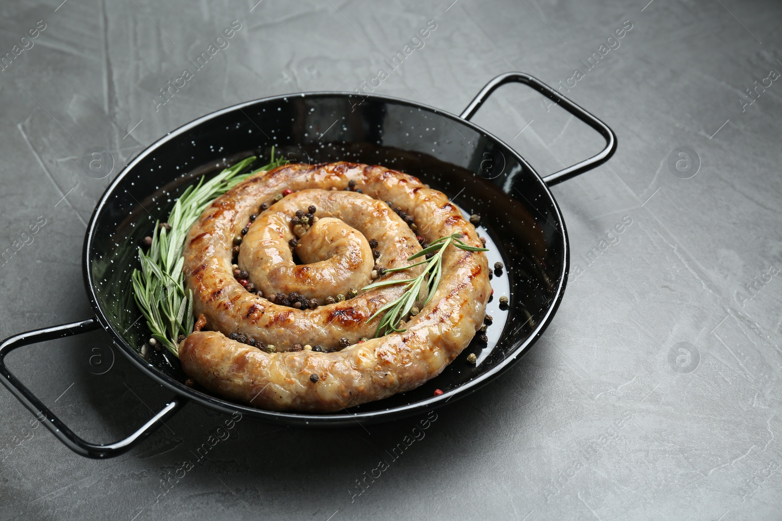 Photo of Tasty homemade sausages with spices on grey table