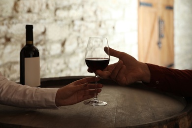 Photo of Waitress serving glass of red wine to client in restaurant, closeup
