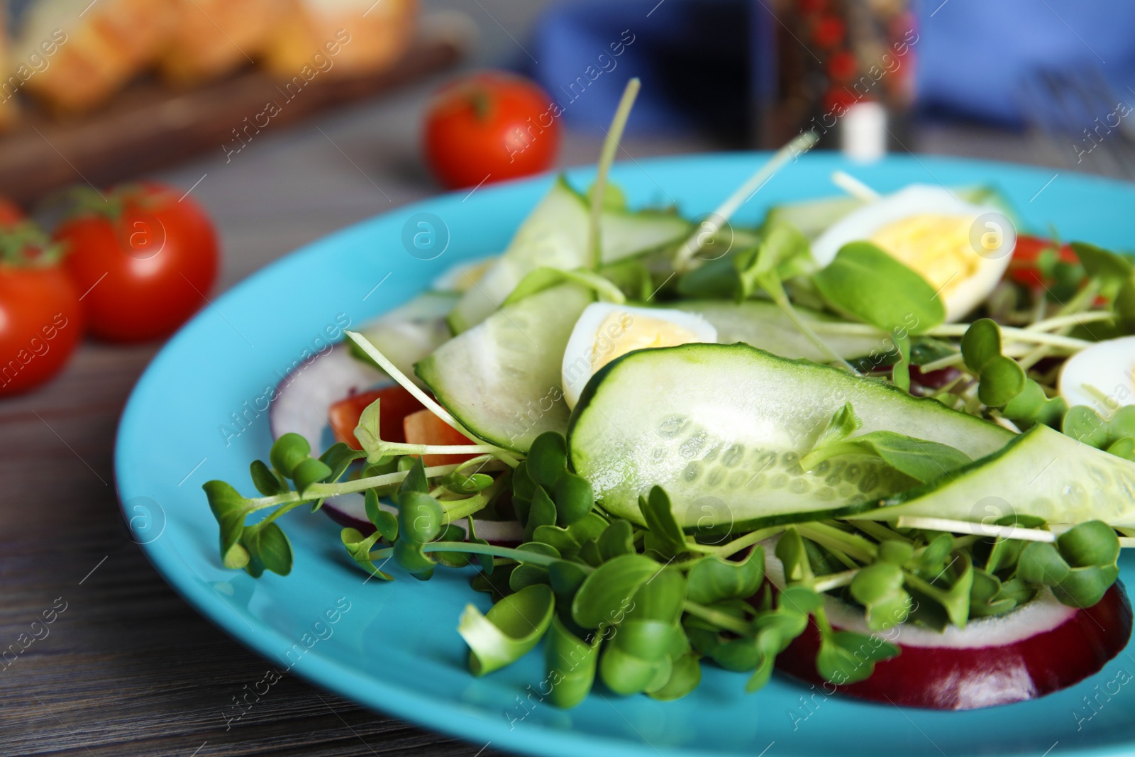 Photo of Salad with fresh organic microgreen in plate on wooden table, closeup