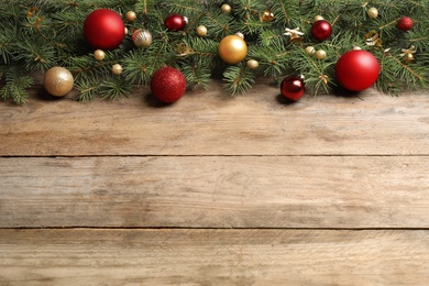 Photo of Fir tree branches with Christmas decoration on wooden background, flat lay. Space for text