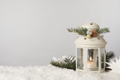 Photo of Beautiful composition with vintage Christmas lantern and festive decorations on snow against white background. Space for text