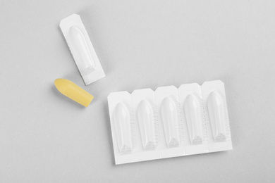 Photo of Suppositories on light background, flat lay. Hemorrhoid treatment