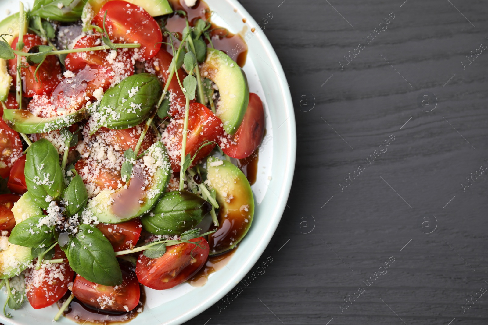 Photo of Tasty salad with balsamic vinegar on grey wooden table, top view. Space for text