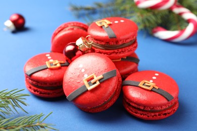 Pile of beautifully decorated Christmas macarons on blue background